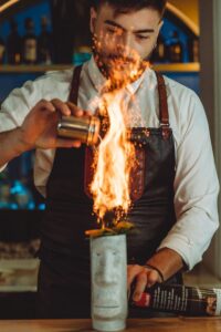 bartender preparando cóctel con fuego en restaurante Baltazares en Sevilla